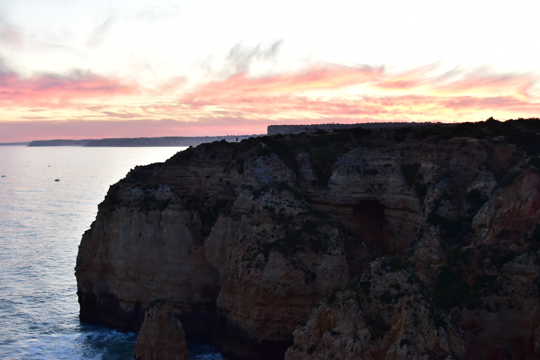 Pôr do sol na Ponta da Piedade — falésias em silhueta