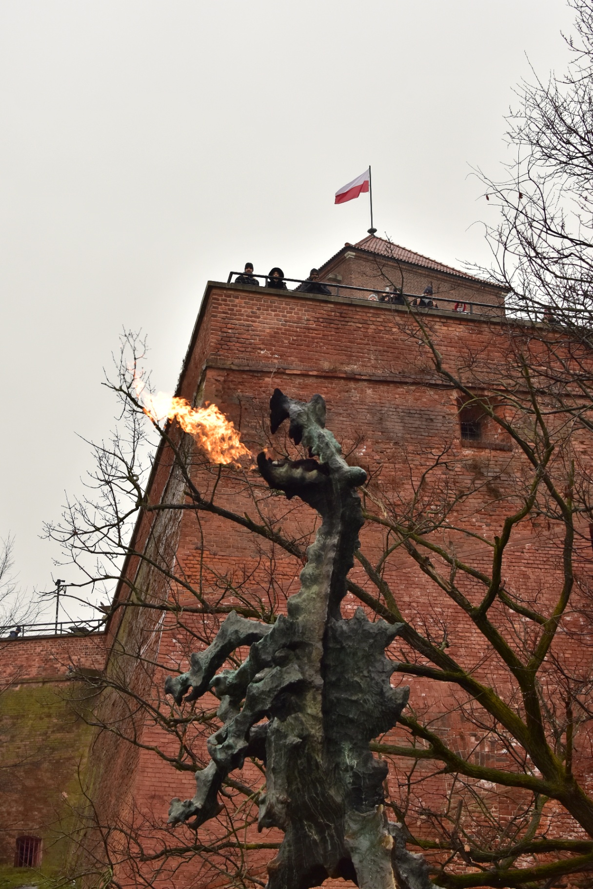 Estátua do Dragão de Wawel com muralhas do castelo ao fundo