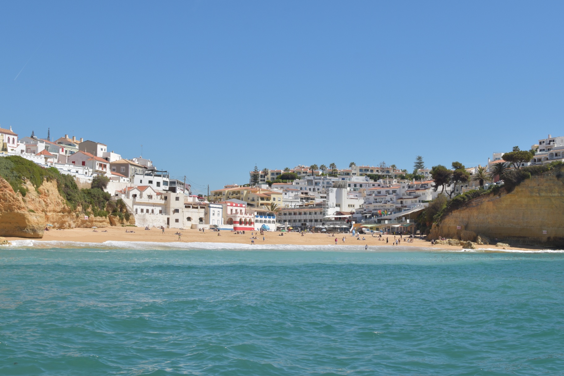 Carvoeiro visto do mar — casarios sobre a praia entre falésias